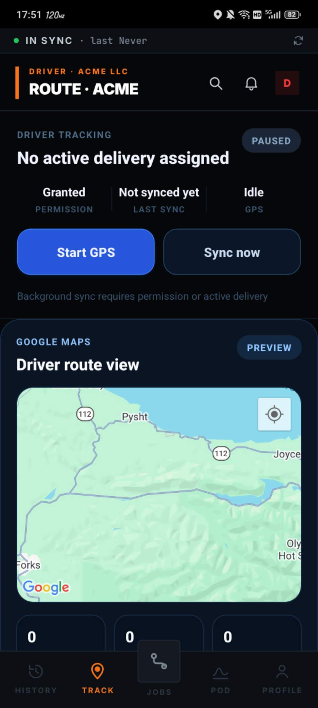 Trenvar Workforce Driver Tracking screen on Android for ACME LLC, showing the route header, a PAUSED tracking badge, 'No active delivery assigned', stats rows for Granted permission, Not synced yet, and Idle GPS, Start GPS and Sync now buttons, a helper message that background sync requires permission or active delivery, and a Google Maps preview titled Driver route view rendering a terrain map of the Pysht / Joyce / Forks region with state route 112 visible. Bottom tab bar shows HISTORY, TRACK selected, JOBS, POD, and PROFILE.